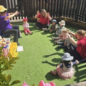 A group of kitchen sat in a circle having fun with their caregivers at The Old Fire Station Nursery in Englefield.